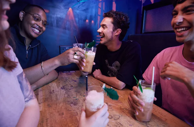 A group of students toasting drinks in a bar.