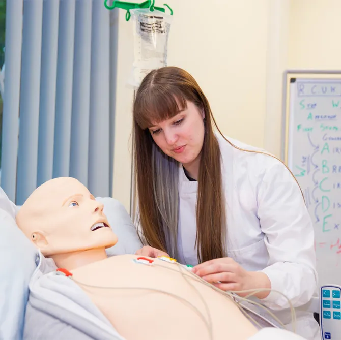 A science student in a practical simulation with a dummy