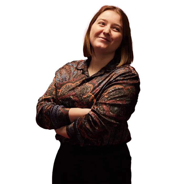Computing graduate, Niamh, smiling with arms crossed.