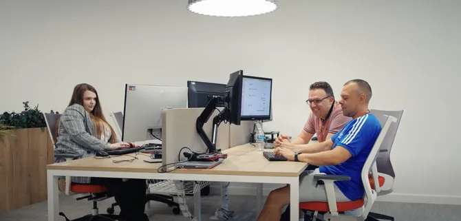 Monmouthshire Building Society staff members sitting around two desks working at computers
