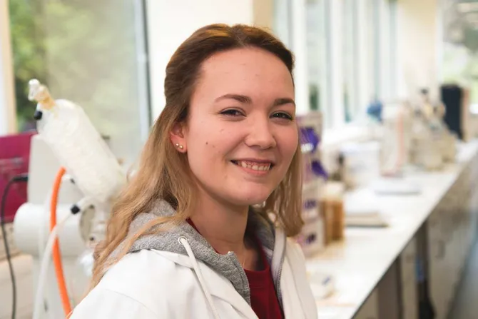 Laura Pegg smiling to camera standing in a pharmaceutical lab