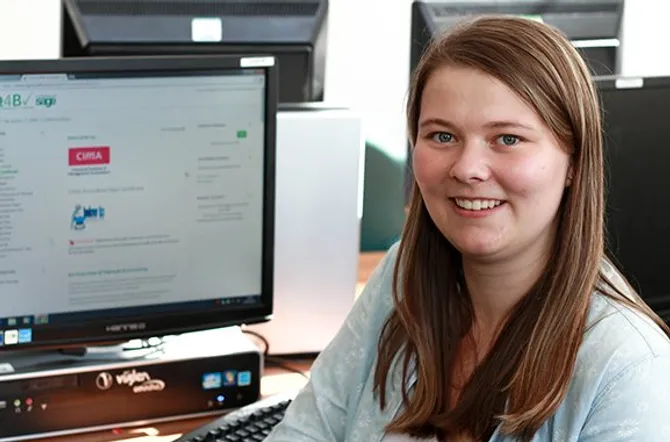 Sarah Liddell sitting in front of a computer with CIMA Sage Accreditation on the screen