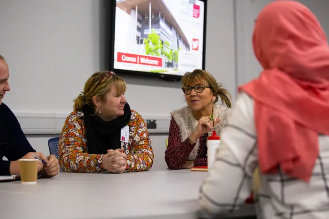 Teachers discussing while sat at a table