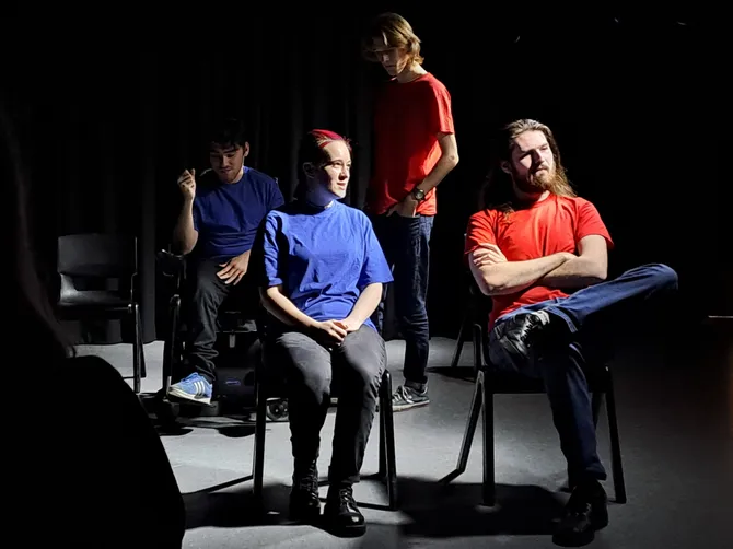 drama and performance students sitting in a drama studio