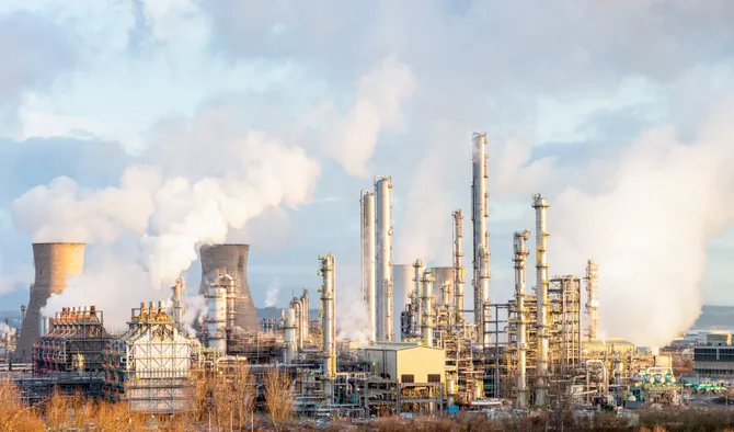 Steam and smoke rising from distillation towers and cooling towers towards the left at Grangemouth oil refinery and petrochemical plant in Central Scotland.