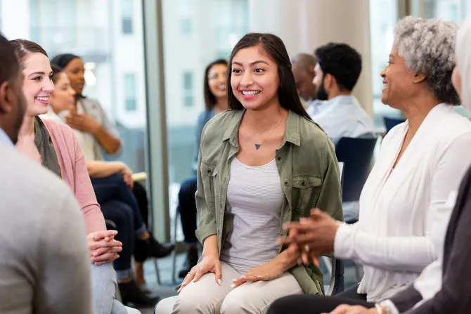 group of people sitting around in a support group talking