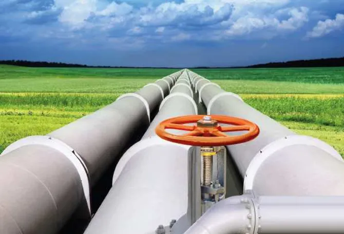 A picture of gas pipes with a field in the background.