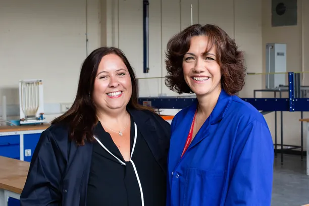Two women in engineering smiling at the camera