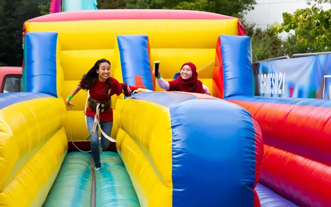 Two students having fun on an inflatable