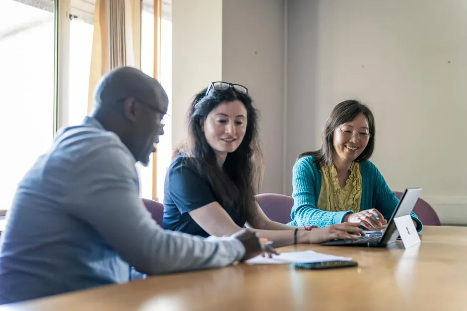 three members of the Ethnic Minority Research Advisory Group sitting at a table having a meeting