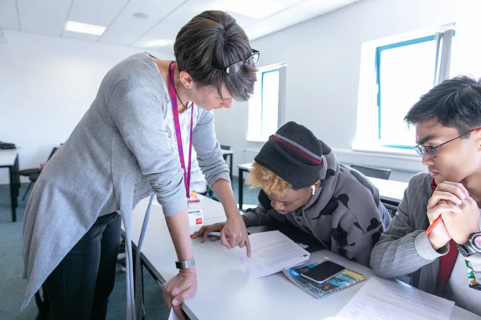 Academic staff talking to students in class