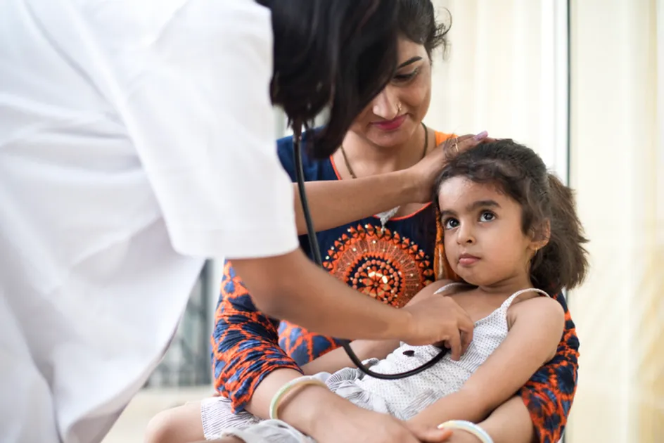 Mother with daughter being examined by doctor