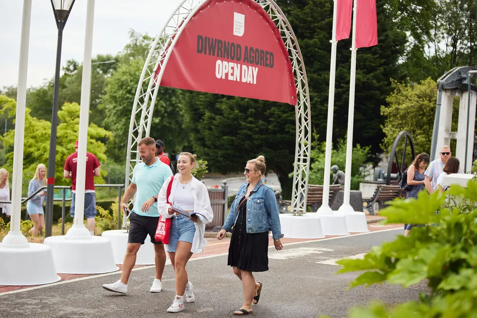Open Day visitors walking through the Treforest campus. There is a large red open day banner behind them.