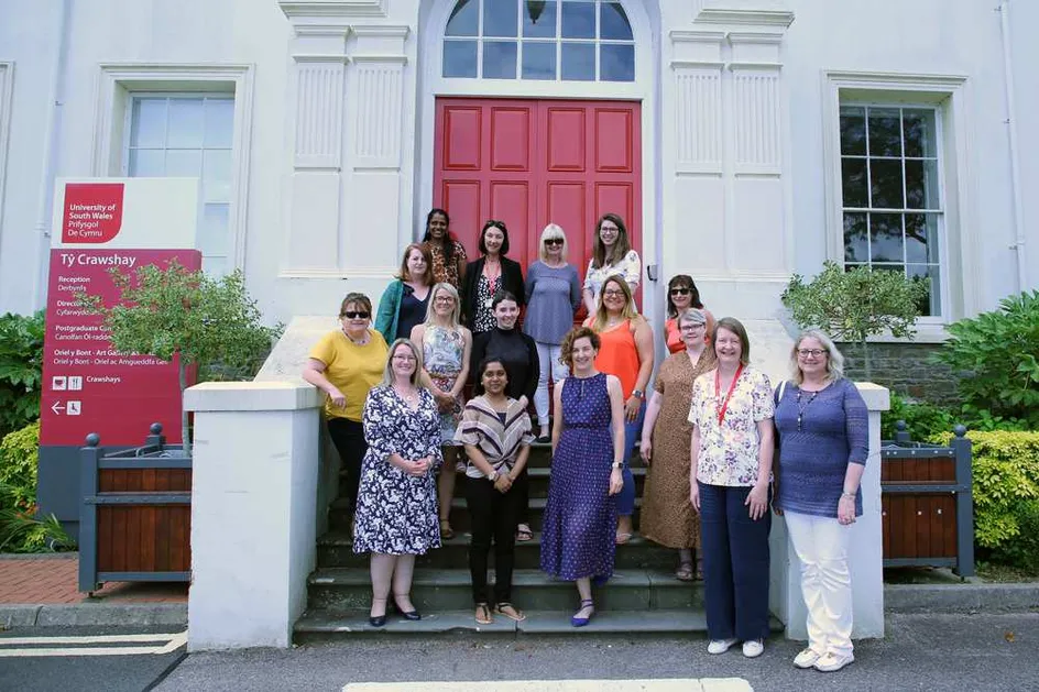 A group of women smiling at the camera in front of Ty Crawshay in Treforest