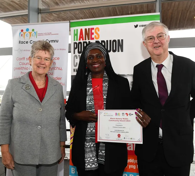 Jane Hutt AS, yr Athro Florence Ayisi, a'r Prif Weinidog Mark Drakeford yn y Senedd, yn gwenu tuag at y camera