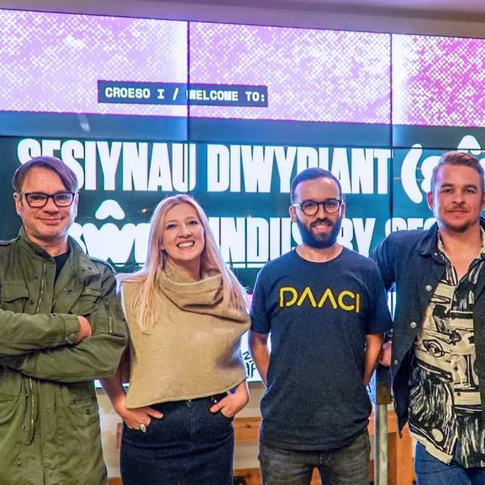 Four people smiling happily at the camera