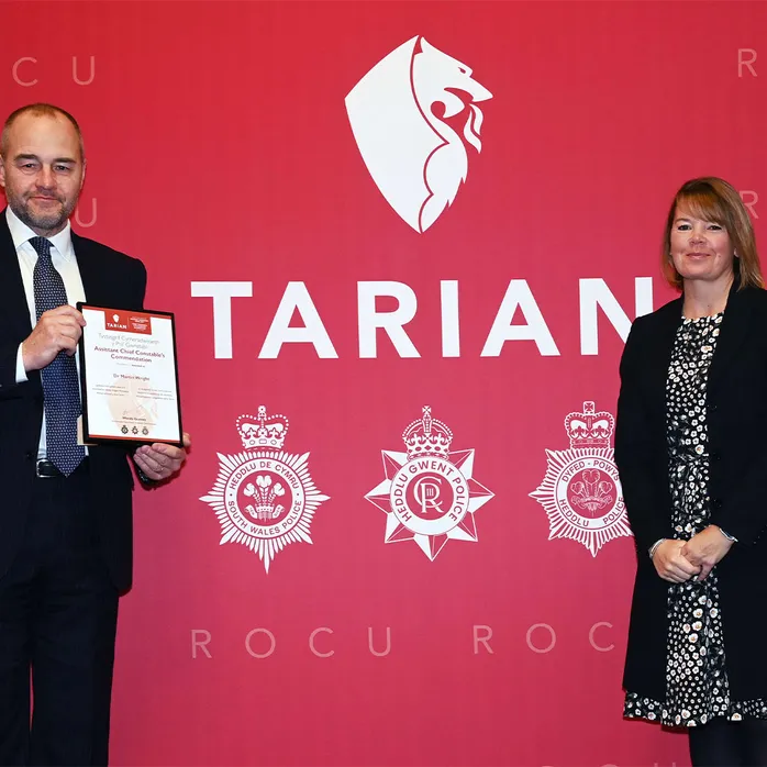 Dr Martin Wright holding his award for establishing the Virtual Volunteers programme at USW with Assistant Chief Constable, Wendy Gunney