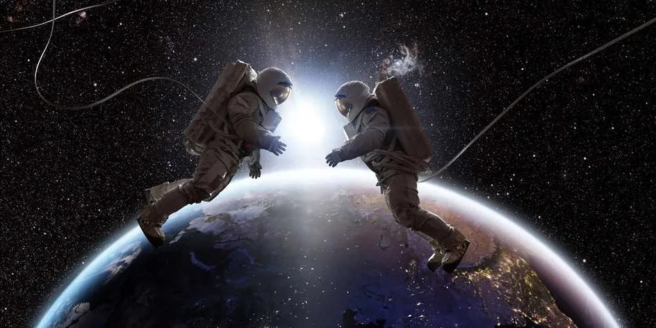 Image of astronauts in space, with the Earth and the Sun visible in the background.