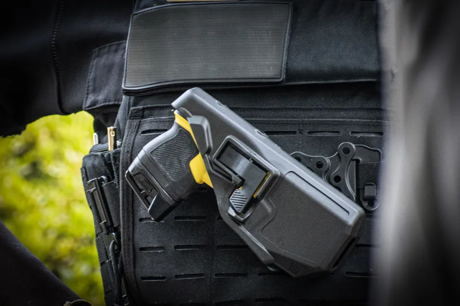 A taser, in a case, being worn on a police officer