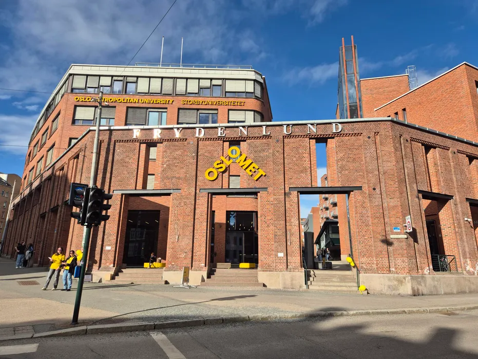 Exterior of Oslo Metropolitan University building made of red brick with large windows and the word 