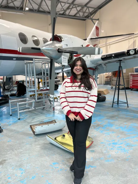 Khadijatul Kaba, in an aircraft hangar at the University of South Wales, stood in front of a propeller aircraft.