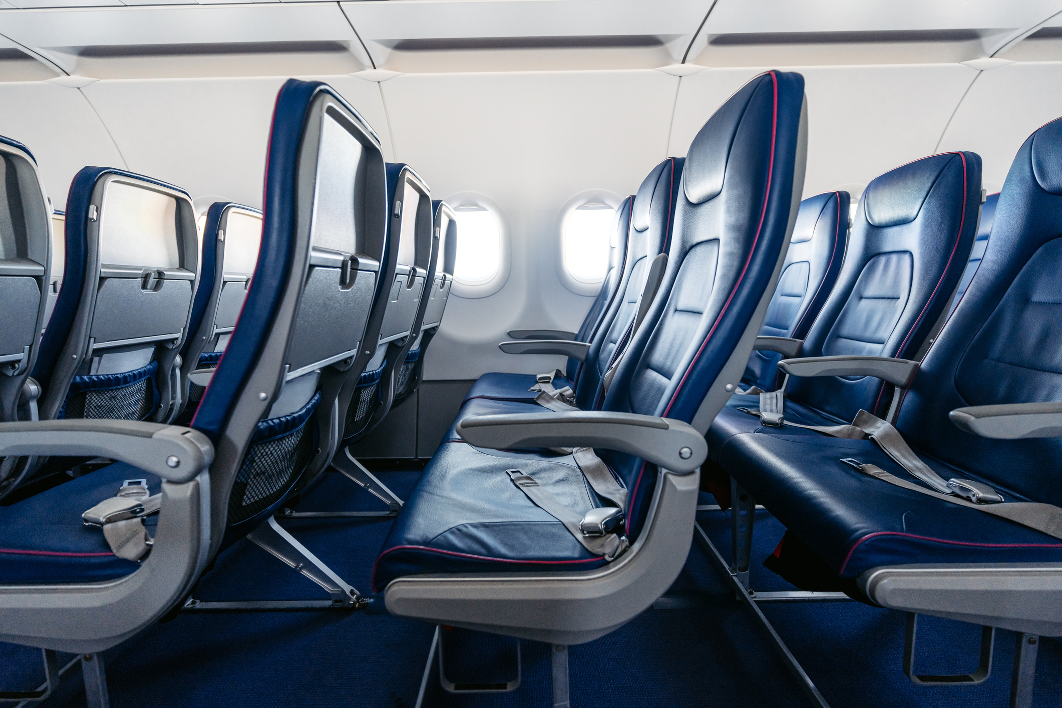 A close up of 3 rows of seats inside a plane