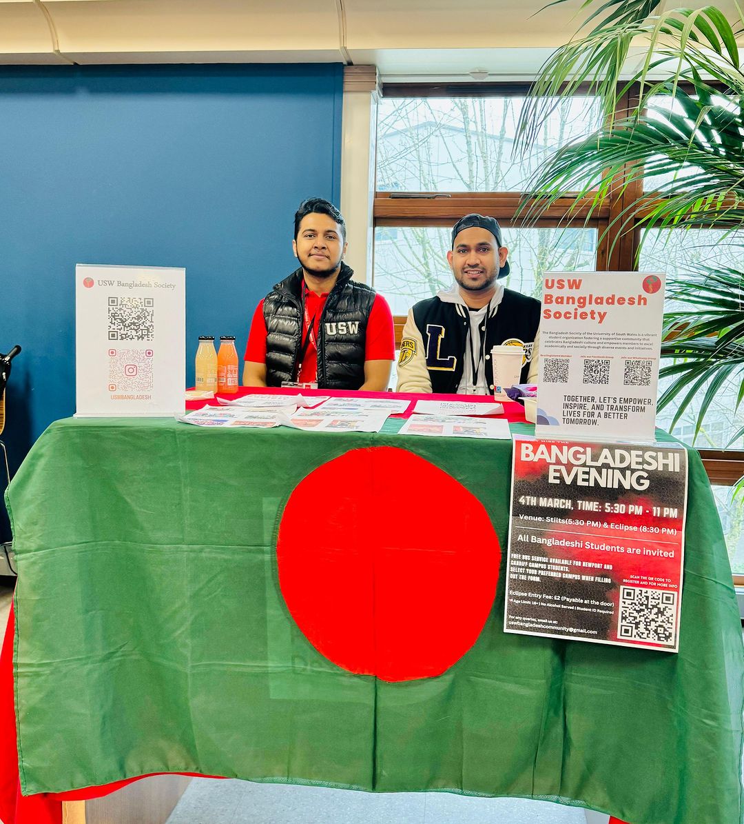 Two international students sat at the Bangladesh society stand at an event