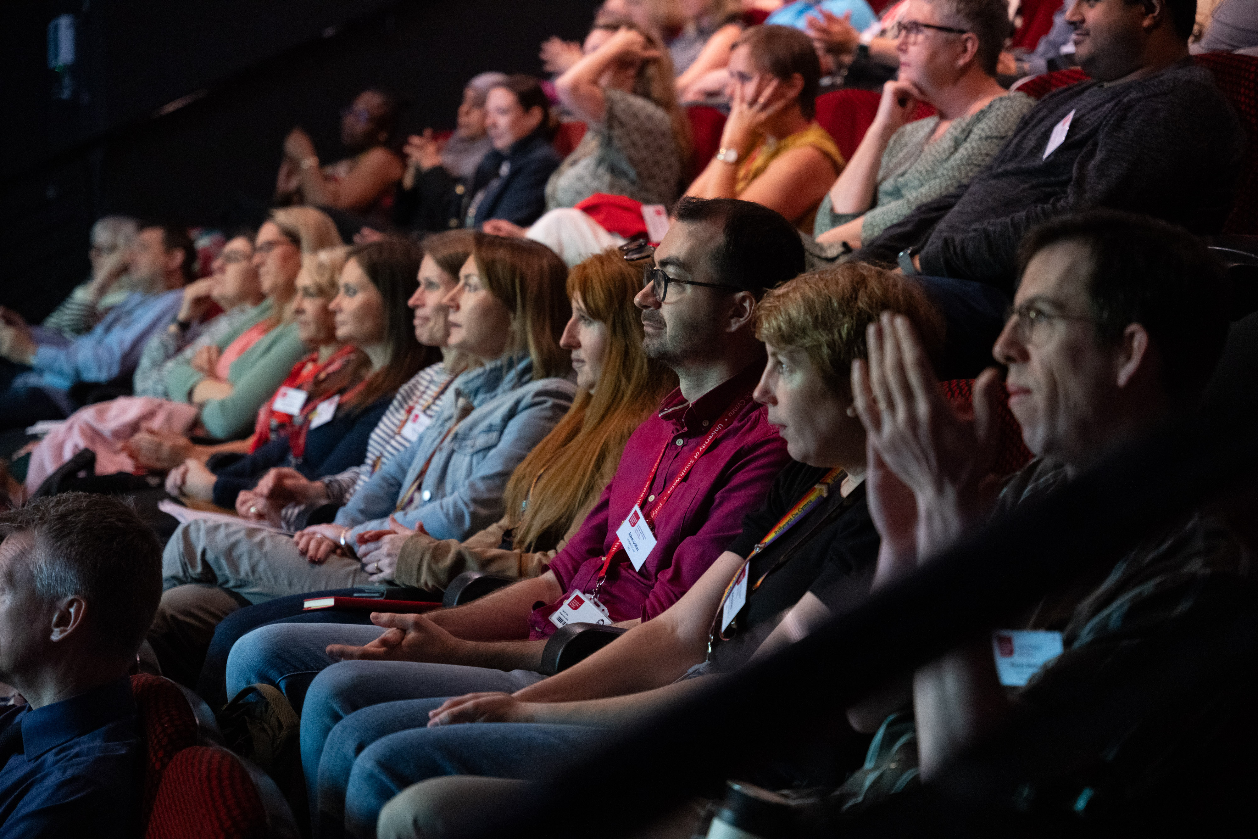 An audience listening to a conference speaker in a lecture theatre.