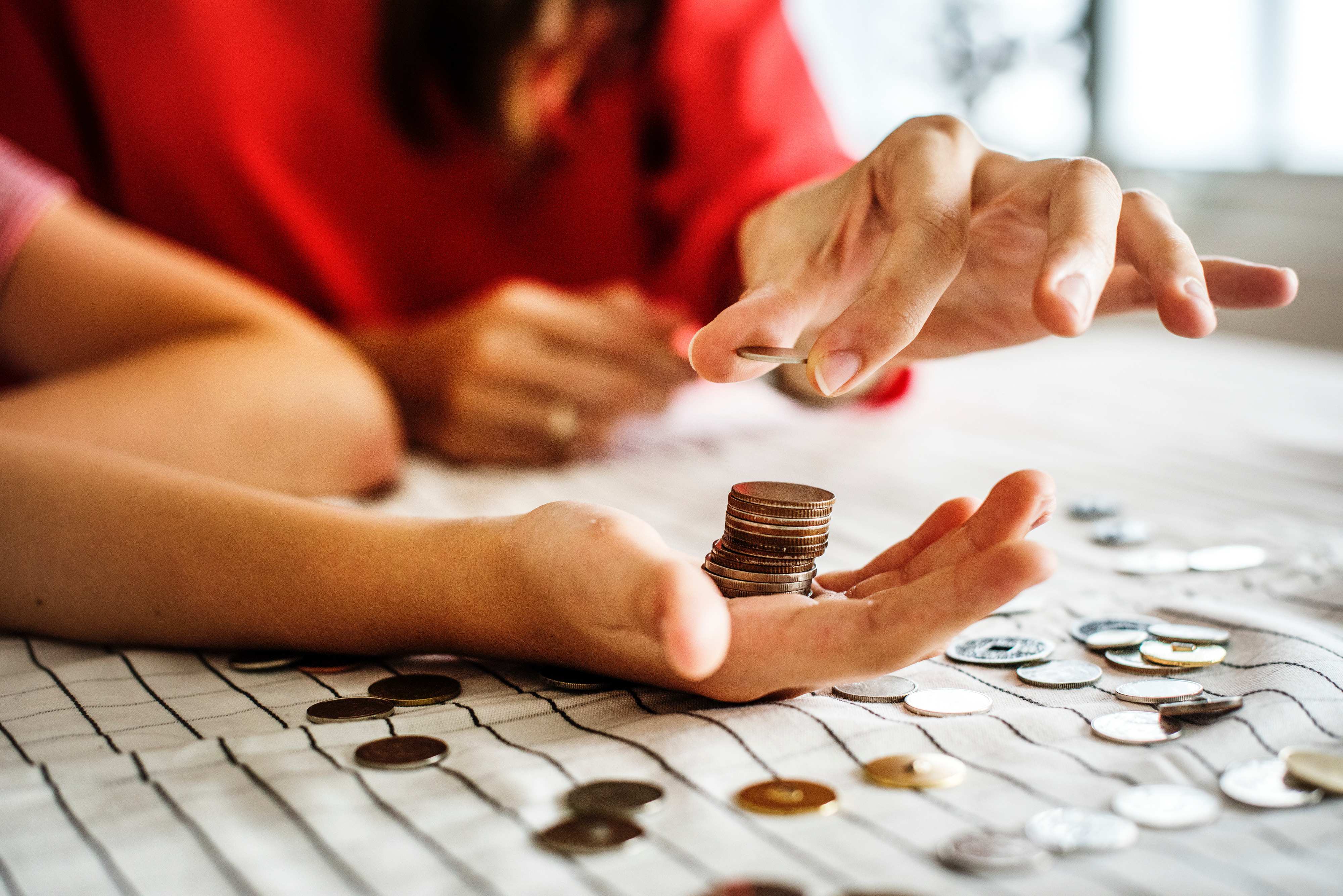 person counting coins into hand