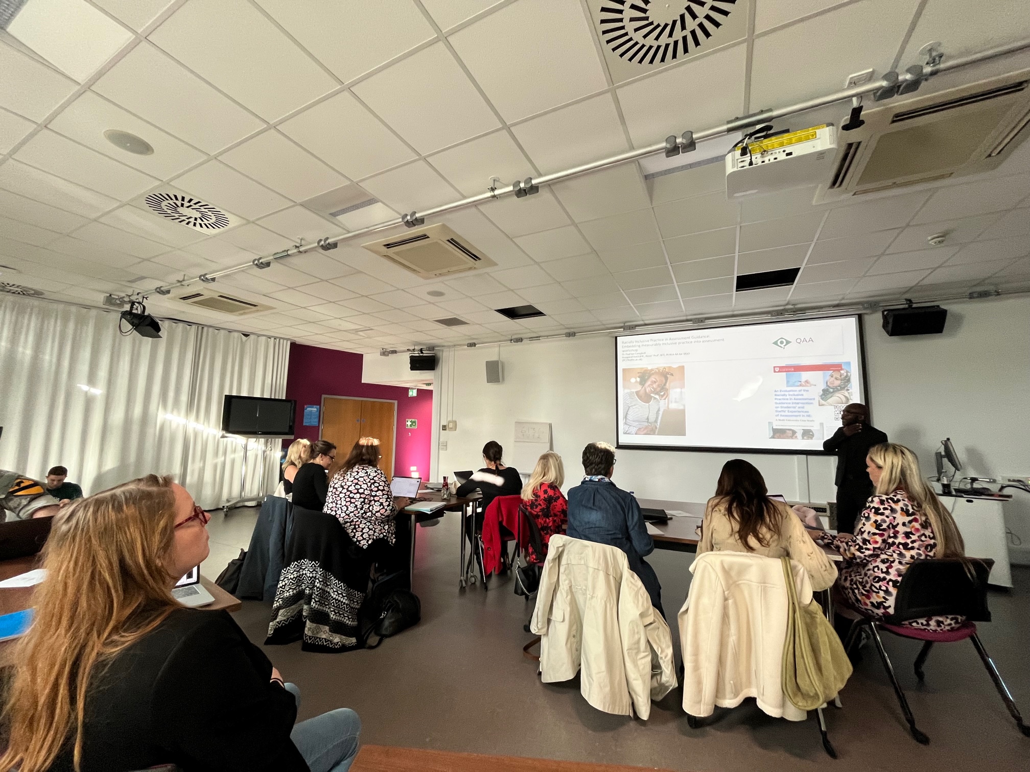 A room of people listening to a seminar being delivered by Paul Campbell.