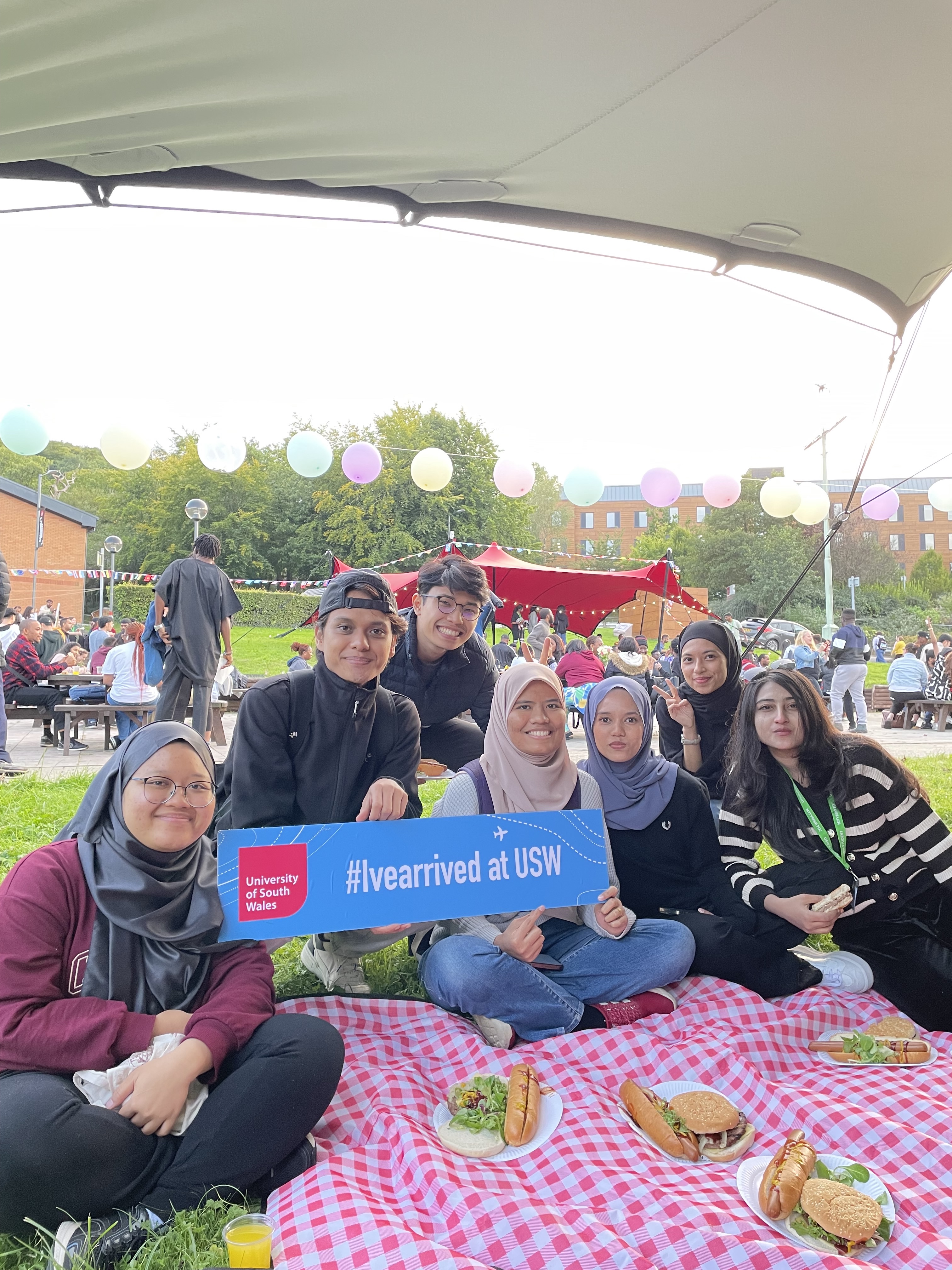 A group of international students sat on the grass in treforest campus