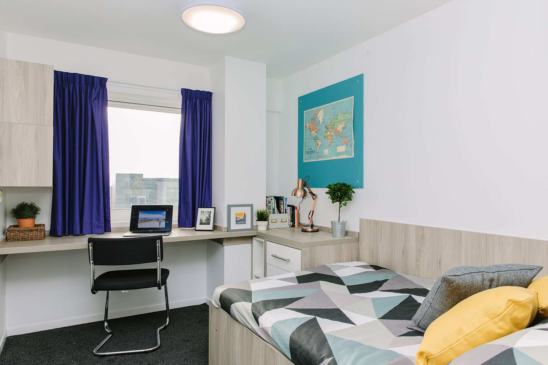 double bedroom in liberty bridge accommodation in cardiff - room contains a bed, desk, cupboard, window and drawers