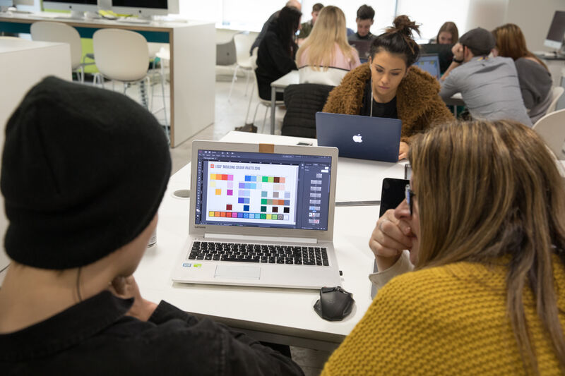 graphic communication students sitting around a computer