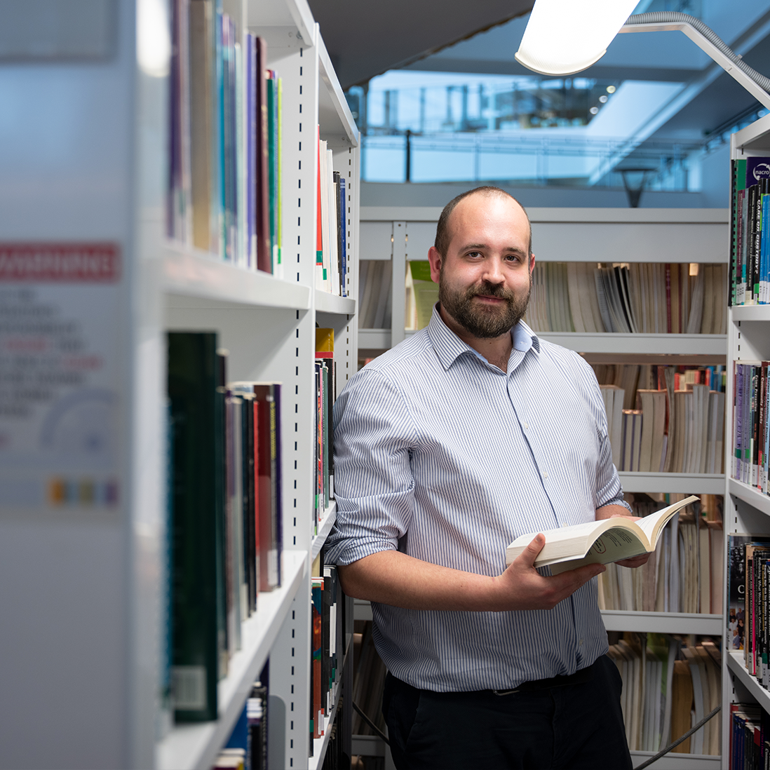 Student holding book in library
