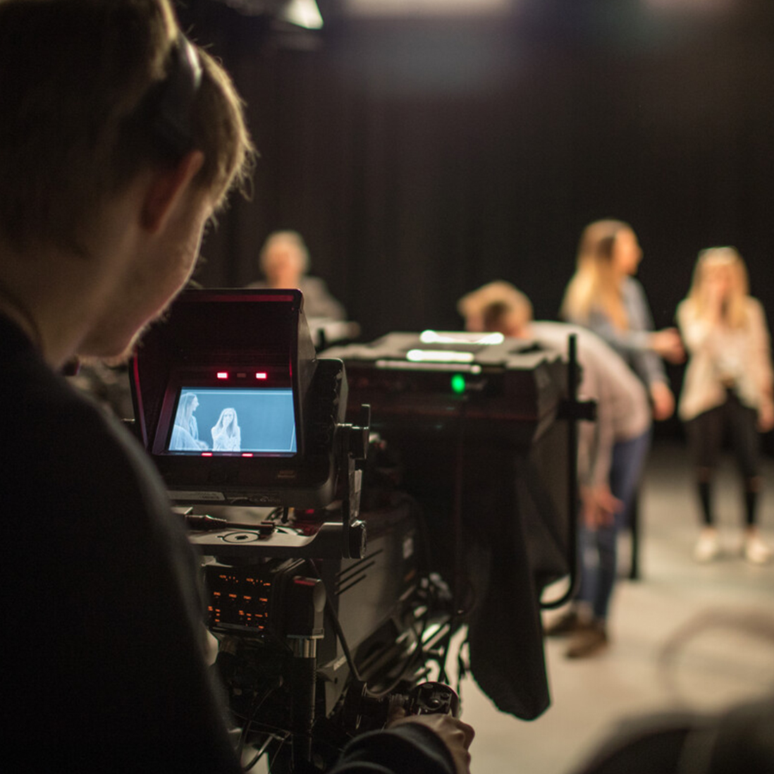 A student operating a camera in a tv studio