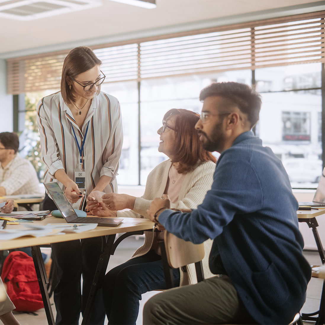 three teaching students sitting around a table