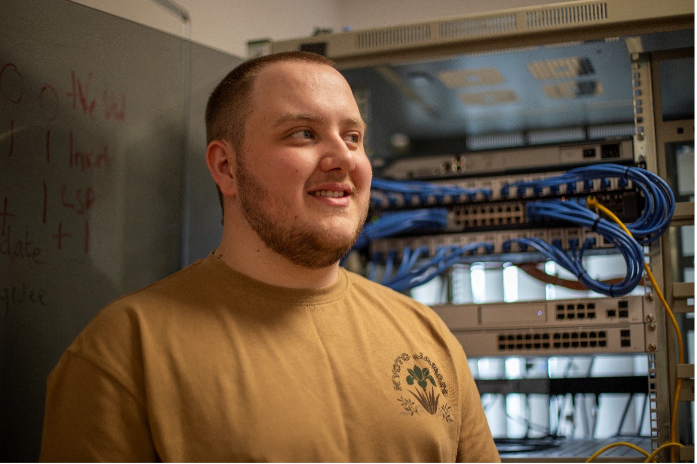 Computing student stood in front of computer servers