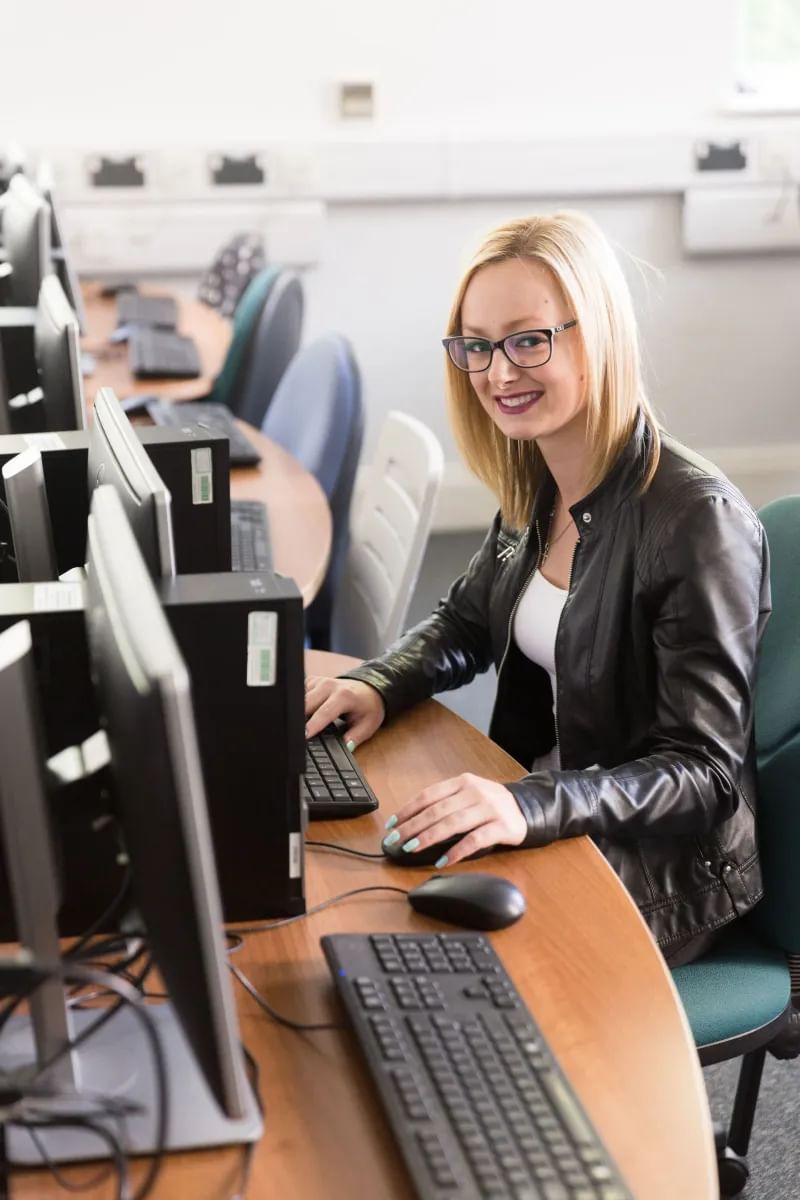 Cyber student, Stephanie, poses for a photo whilst using a computer