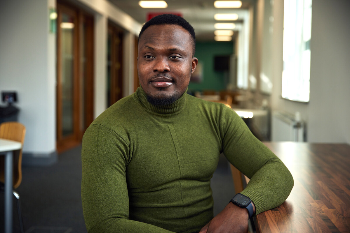 Student Chidiebere Ejiogu sits at a table in Treforest campus's Postgraduate Centre