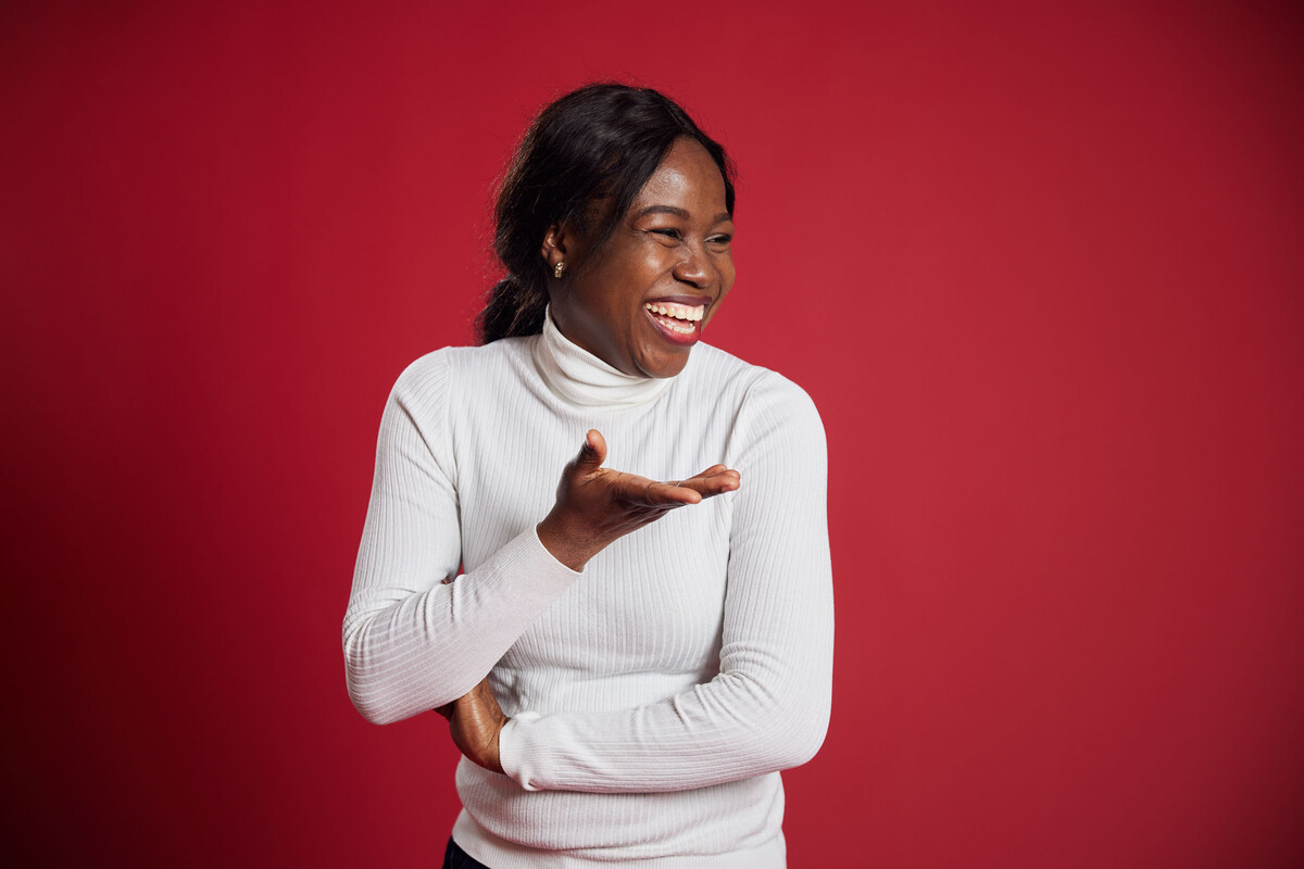 Student Chidinma Fofah laughs in front of a red backdrop