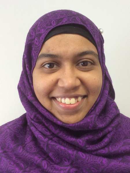 Shereen Williams, honorary chaplain, smiling to camera in front of a white wall