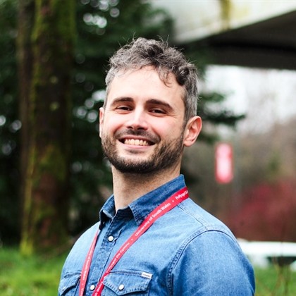 A photo of Nico Paolucci smiling at the camera on campus