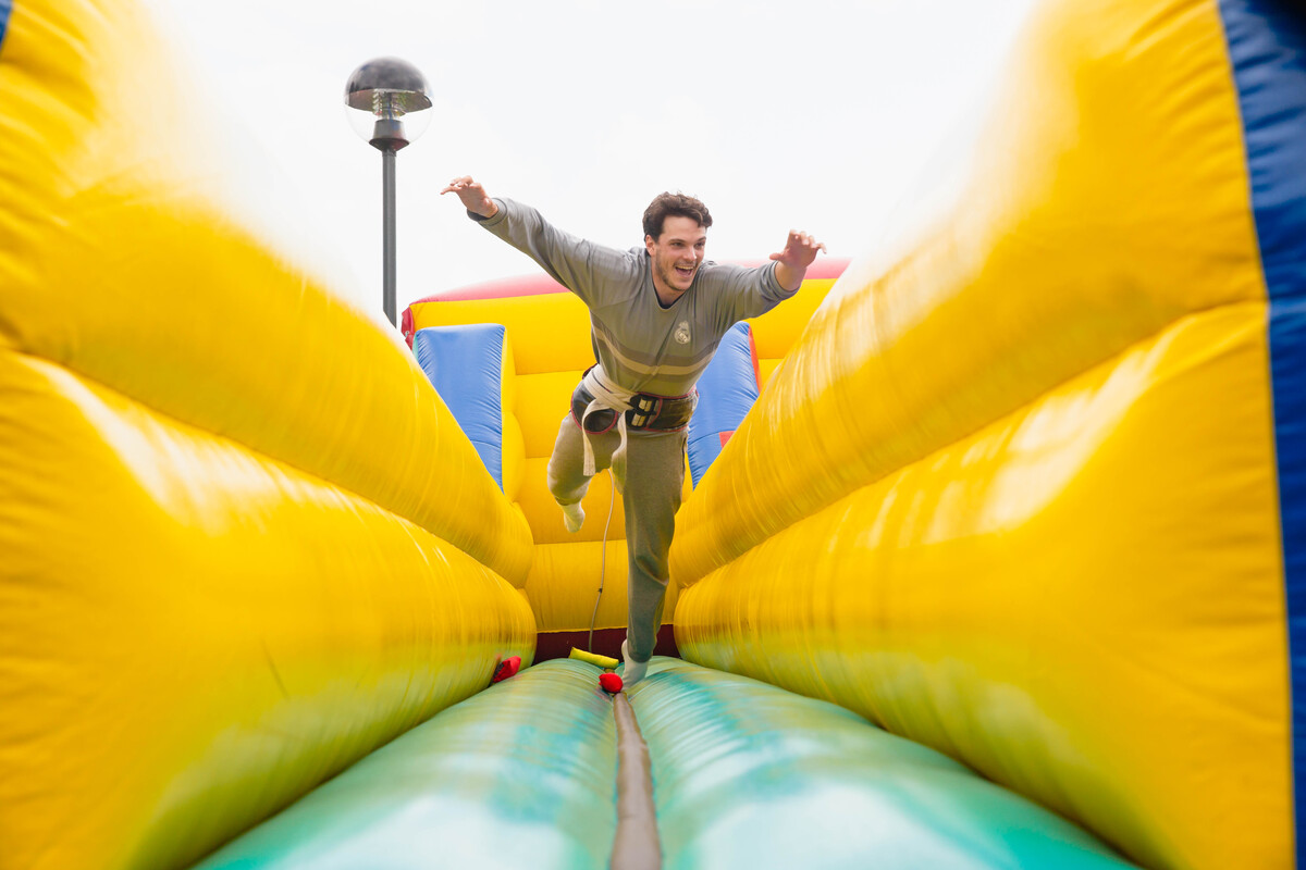A student jumping whilst playing on a bouncy castle style inflatable