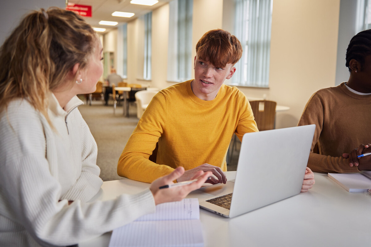 Students studying on a laptop and talking.