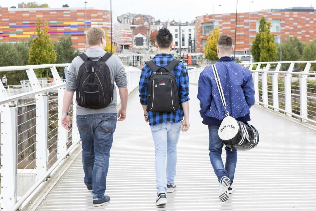 three students walking through newport city
