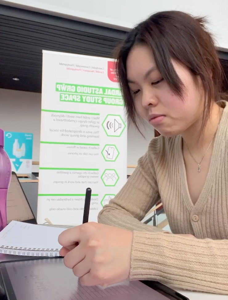 A student taking notes on an iPad.