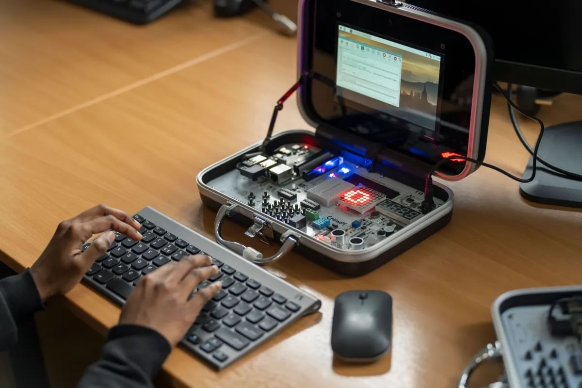 Unrecognisable hands typing code in to a Raspberry Pi device