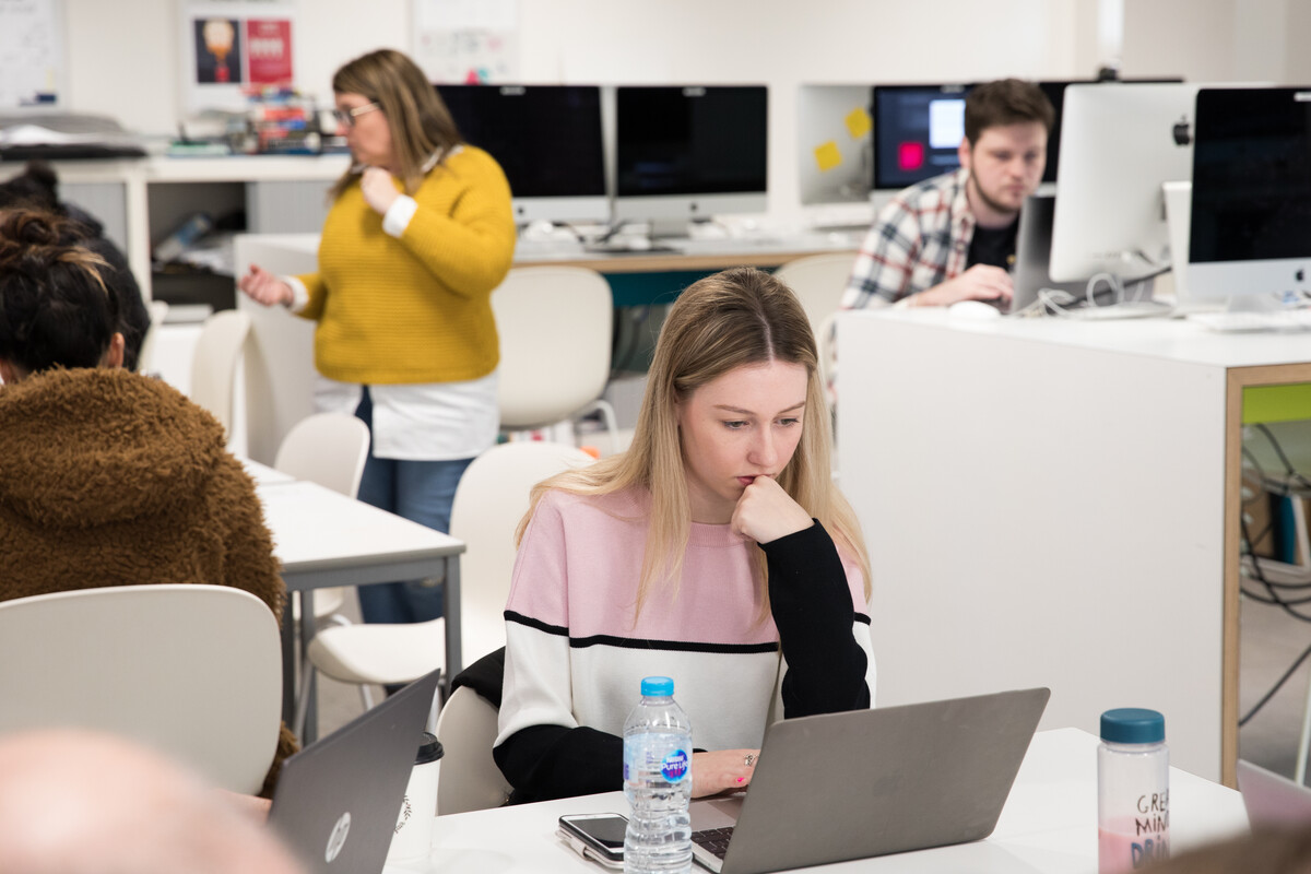 graphic communications students working in the design studio at laptops