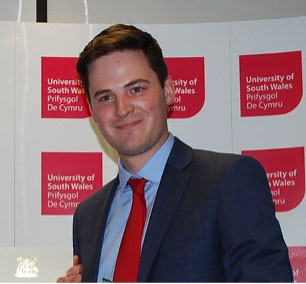 Graduate, Josh, smiles for a photo after receiving the ICE Wales Cymru Prize for Best Civil Engineering Student