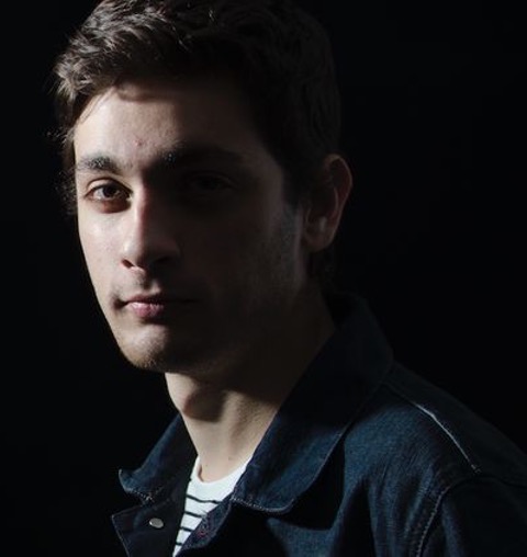Matteo looks intensely at the camera, wearing a denim jacket